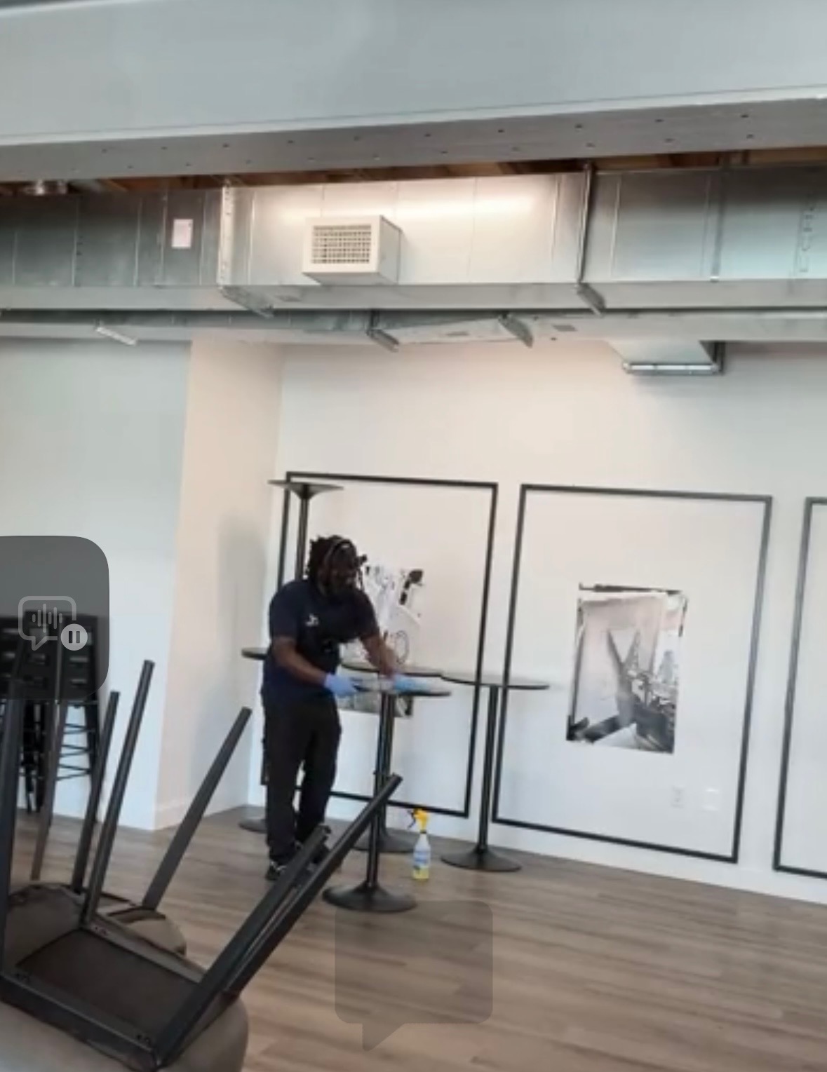 Next Level Commercial Cleaning professional wiping surfaces with blue gloves in a modern office